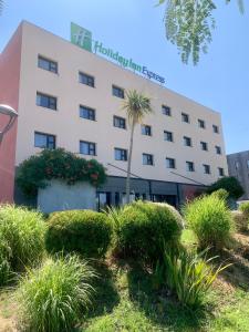 维特罗勒马赛普罗旺斯区机场基里亚德酒店的一座建筑前有棕榈树的酒店
