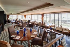 多诺赫皇家高尔夫酒店的餐厅设有桌椅和大窗户。