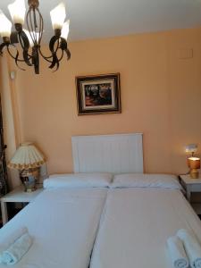 雷塔马尔Casa Cabo de Gata的卧室配有2张白色床和吊灯