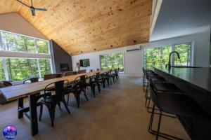 MansonvilleChalet Forestria - SPA- Billard- Ski的大房间设有长排的桌椅
