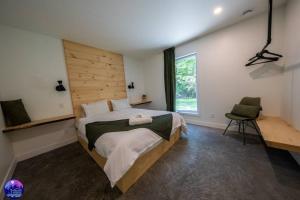 MansonvilleChalet Forestria - SPA- Billard- Ski的一间卧室设有一张大床和一个窗户。