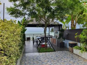 Ban PhalaGrace Seaview บ้านพักส่วนตัว 3 ห้องนอน วิวทะเล หาดพลา的一个带桌子的海景庭院