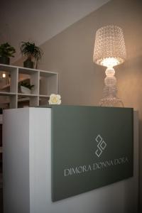 圣马蒂诺－因彭西利斯Dimora Donna Dora - Albergo Diffuso的台灯,挂在台台上,有标志