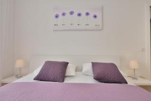 扎达尔Eden Penthouse Apartments的一间卧室配有一张紫色床和两个紫色枕头