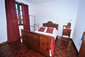 英雄港Casa da Salga的一间卧室配有带白色床单和红色枕头的床。
