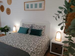 米尔芳提斯城Apartamento Estúdio Pinhalmar的一间卧室配有一张带绿色枕头的床和两盏灯。