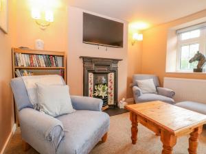 莱奇莱德Halfpenny Cottage的客厅配有两把椅子和壁炉