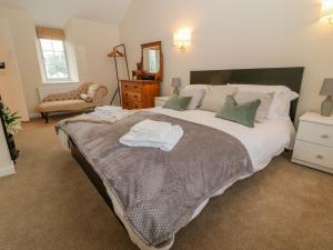 莱奇莱德Halfpenny Cottage的一间卧室配有一张大床和毛巾