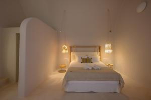 梅加洛克里Elements Cave Suites的一间卧室配有一张大床和两盏灯