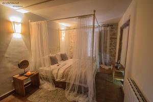 埃尔莫拉尔萝拉公寓的一间卧室配有一张带天蓬的床