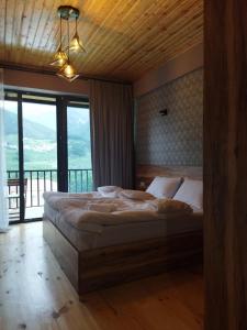 卡兹贝吉Best view Kazbegi的一间卧室设有一张大床和大窗户