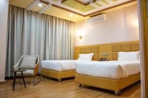 瓦加杜古SAMI HOTEL的酒店客房,配有两张床和椅子