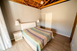 圣洛伦索Casa de campo com piscina cascata artificial的一间小卧室,配有一张床和木制天花板