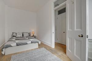 伦敦Flat C, Old Street的一间白色的卧室,配有床和门