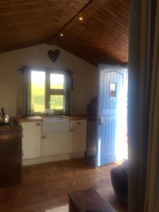 GamrieCroft B&B Accommodation With Hot Tub的厨房设有蓝色的门和窗户。