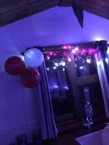 GamrieCroft B&B Accommodation With Hot Tub的一间设有气球和圣诞灯的窗户的房间