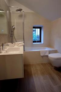 奥帕提亚Noa's Suite的浴室配有盥洗盆、卫生间和浴缸。