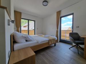 博希尼Apartments Vila Darja的一间卧室配有一张床、一张书桌和一个窗户。