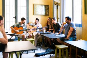 格拉纳达Hostel Carlota Braun的一群坐在桌边弹吉他的人