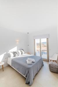 帕罗斯岛CAMPO SUITES的白色卧室配有一张大床和毛巾