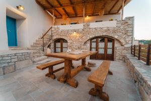 ViarádhikaKythera secrets suites的石墙客房内的木桌和长凳