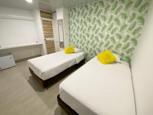 圣安德烈斯OCEANA HOTEL的客房 - 带两张带黄色枕头的床
