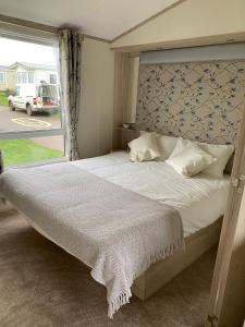 ScratbyHeron 41, Scratby - California Cliffs, Parkdean, sleeps 6, pet friendly, bed linen and towels included - close to the beach的卧室配有一张大白色床和窗户