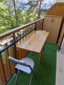 欧龙Studio 4 couchages的阳台配有一张木桌和一把椅子
