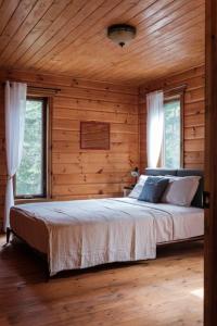 Rivière-RougeChalet Bonheur -Rustique- Pet friendly的卧室配有木墙和窗户。