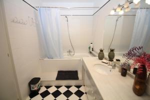 巴塞罗那Rooms Aribau的一间带水槽、浴缸和镜子的浴室
