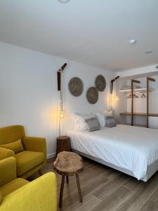 赞布热拉-杜马尔Alojamento White Rose Boutique的卧室配有白色的床和黄色椅子