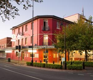 沃加沃加Romano's Hotel & Suites Wagga Wagga的街道拐角处的红色建筑