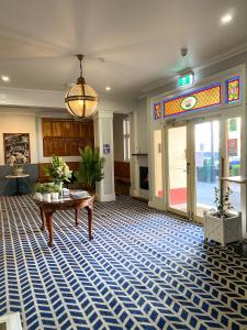 沃加沃加Romano's Hotel & Suites Wagga Wagga的大堂设有桌子和玻璃门