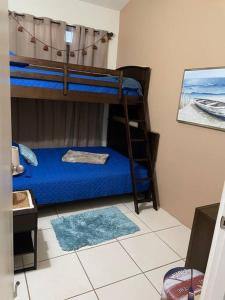 阿瓜达VILLA SEA BEACH的一间卧室配有两张双层床,铺有蓝色床单。
