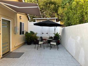 洛杉矶New Contemporary Guest House in Studio City Hills的庭院配有桌椅和遮阳伞。