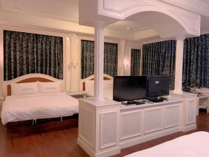 台东旅行家商务会馆的一间卧室配有一张床和一台平面电视