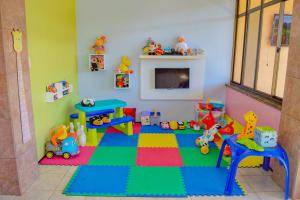 瓜拉米兰加Le Rêve Pousada e Restaurante的儿童游戏室,配有玩具和壁炉
