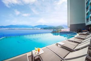 丽水市Utop Marina Hotel & Resort的酒店游泳池设有椅子,享有水景