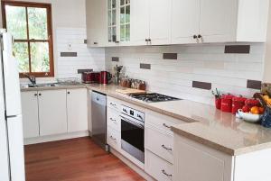 穆伦宾比Mullumbimby Studio的厨房配有白色橱柜和炉灶烤箱。