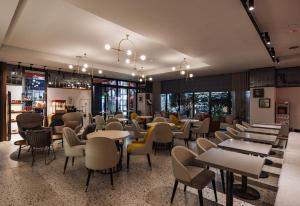 台中市悦乐旅店- 台中站前的餐厅设有桌椅和窗户。
