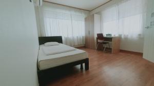 首尔克里宾馆的一间卧室配有一张床、一张桌子和一把椅子