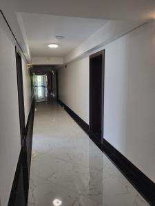 厄尔科Selment Resort的走廊设有白色墙壁和瓷砖地板