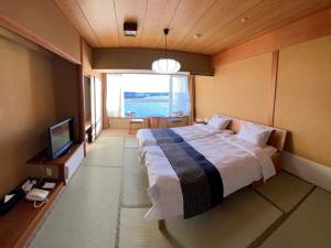滨松西米皇家酒店的一间卧室配有一张大床和电视