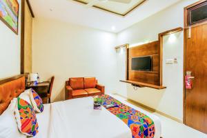孟买FabHotel Empire Suite的配有一张床和一把椅子的酒店客房