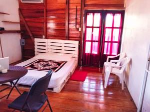 博卡斯德尔托罗Poetry Garden Bocas Town Colon Island- Deluxe Bungalow Cabin-AC-Enjoy the Night Life的卧室配有一张床和一张桌子及椅子