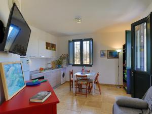 萨尔维Casa Barzò - surrounded by olive trees的厨房、带红色桌子的客厅和用餐室