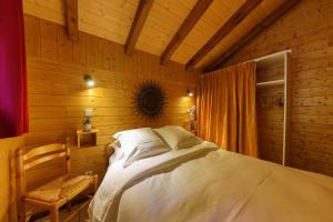 SoultzerenChalet Anemone的木制客房内的一间卧室,配有一张床