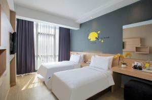 万隆Rooms Inc BTC Bandung的酒店客房配有两张床和一张书桌