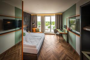 柏林LOGINN Hotel Berlin Airport的配有一张床和一张书桌的酒店客房