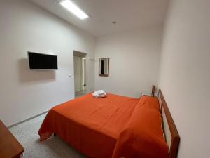 卡普里La Musa的一间卧室配有一张带橙色毯子的床